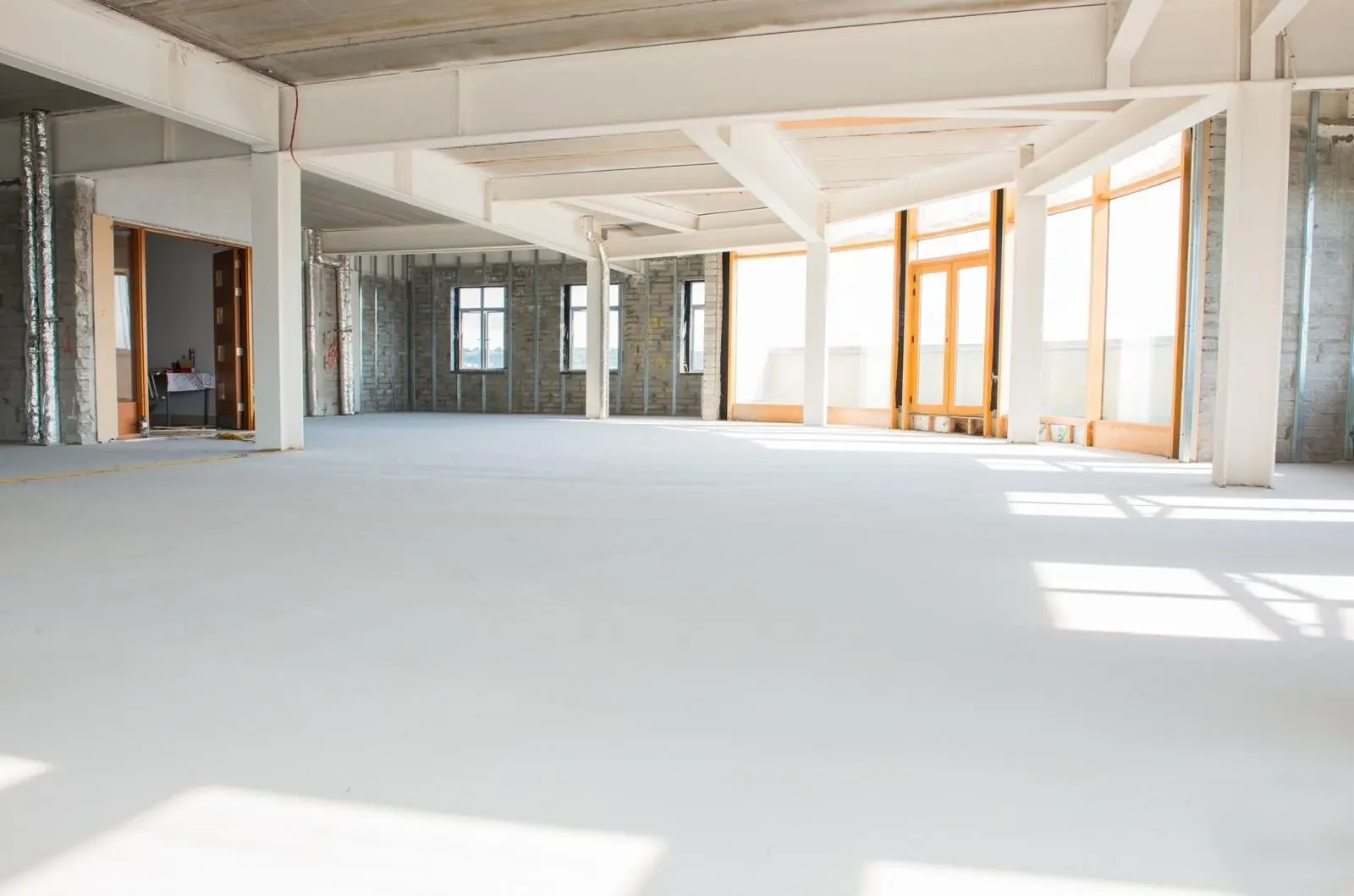 Large sunlit commercial interior with a smooth prepared floor